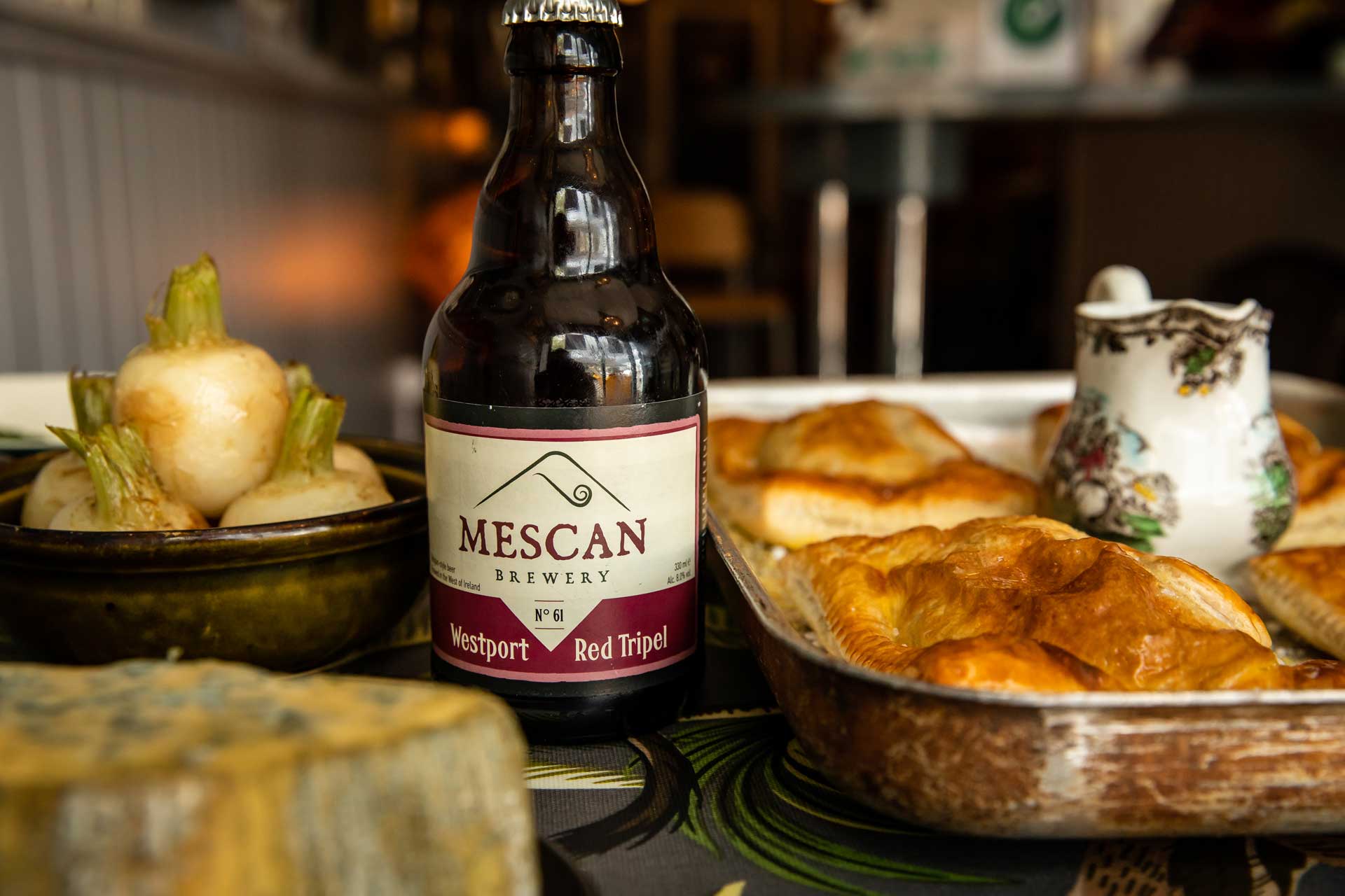 A bottle of Westport Red Tripel next to some food